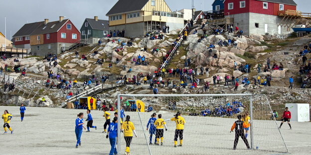 Fußballerinnen spielen in Illulisat/Westgrönland, im Hintergrund Häuser