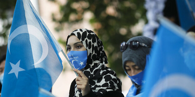 Demonstrantin, Uiguren-Fahnen