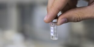 Eine Han hält ein Fläschchen mit einer Substanz, die auf Doping getestet werden soll