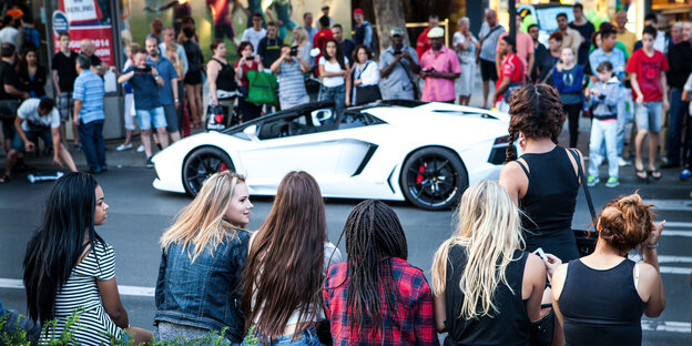 Eine Menschenmenge steht um einen Lamborghini heraum