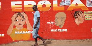 Mauer mit Aufklärungs-Wandbild zu Ebola