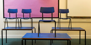 Stühle stehen auf Tischen in einem Klassenraum