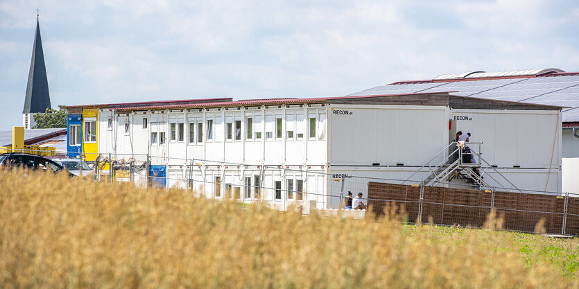 Eine Containersiedlung, im Hintergrund ein Kirchturm