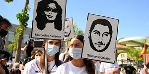 Frauen halten Schilder mit den stilisierten Gesichtern von Gökhan Gültekin, Mercedes Kierpacz und anderen Opfern des Anschlags in Hanau