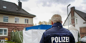 Ein Polizist steht vor Wohnhäusern