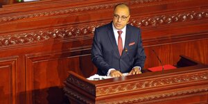 Hichem Mechichi, der neue tunesische Ministerpräsident steht an einem Rednerpult und sprict