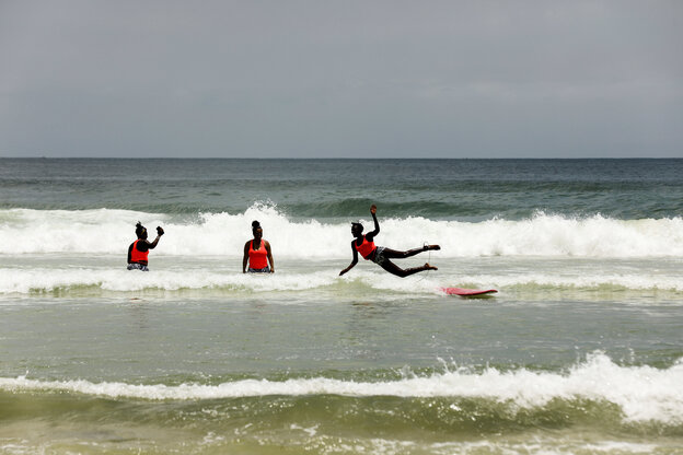 Mädchen in denflachen Wellen beim Surftraining