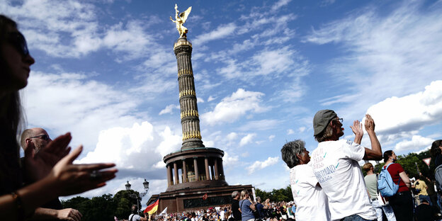 Eine Menschenmenge protestiert an der Berliner Siegessäule