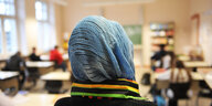 Eine Frau trägt ein Kopftuch in einem Klassenraum
