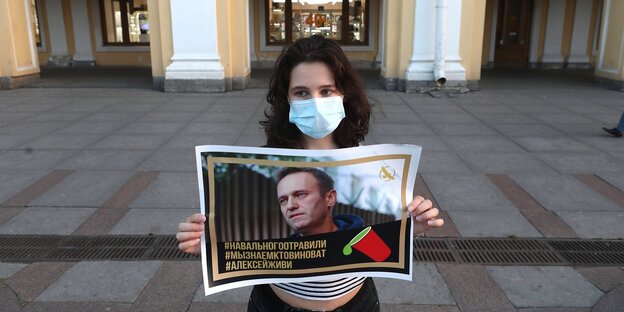 Eine Frau hält ein Plakat mit einem Foto von Alexei Nawalny