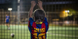 Ein Kind trägt das Trikot von Messi.