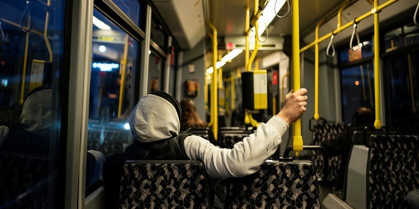 Ein mann hält sich an einer Haltestange in einer Straßenbahn fest