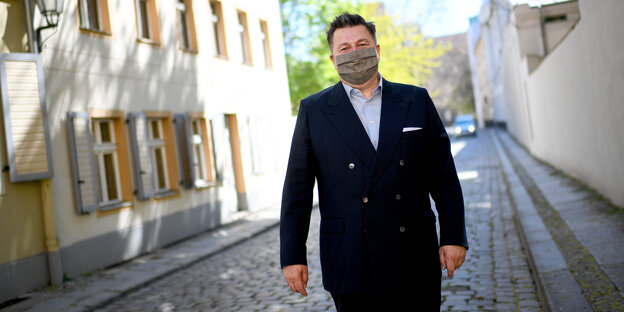 Der Berliner Innensenator Andreas Geisel von der SPD trägt zum dunklen Anzug eine hellgraue Maske.