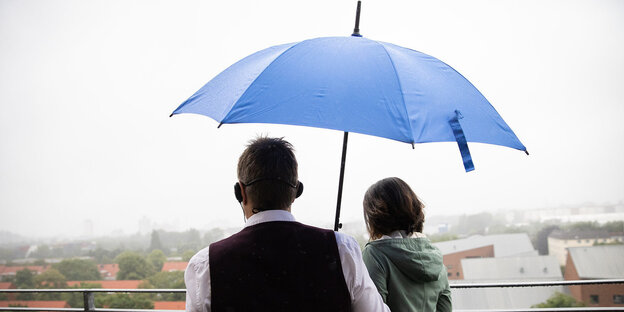 Mann und Frau unter einem Regenmschirm