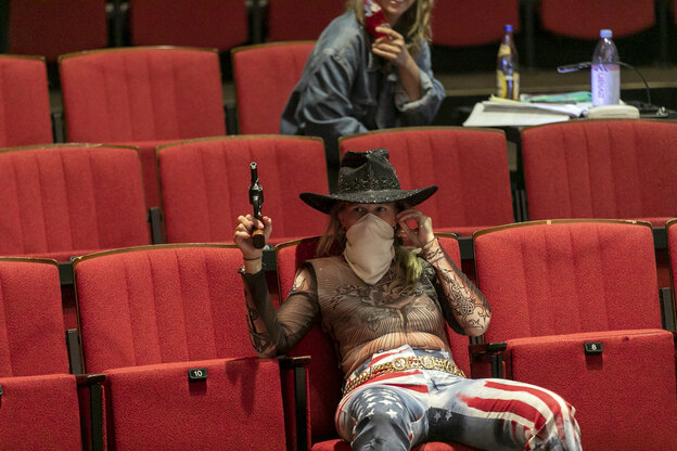 Eine Frau als Cowboy verkleidet im Sessel Eine Frau als Cowboy verkleidet im Sessel