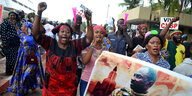 Schwarze Frauen laufen protestierend und mit erhobenen Fäusten durch eine Straße