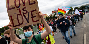 Menschen laufen bei der Pride-Parade durch eine Straße