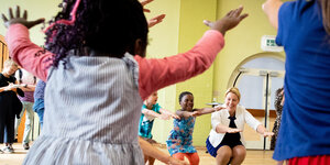 Kinder hüpfen mit Familienministerin Giffey im Kreis