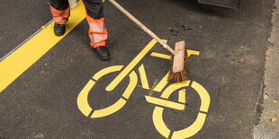 Ein zeichen für einen radweg wird auf die Straße geklebt