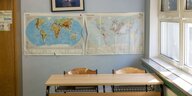Leeres Klassenzimmer mit Weltkarte im Hintergrund