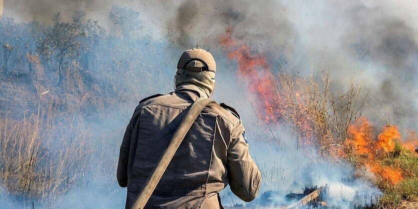 Ein Feuerwehrmann hatsich einen feuerwehrschlauch über die Schulter gehängt