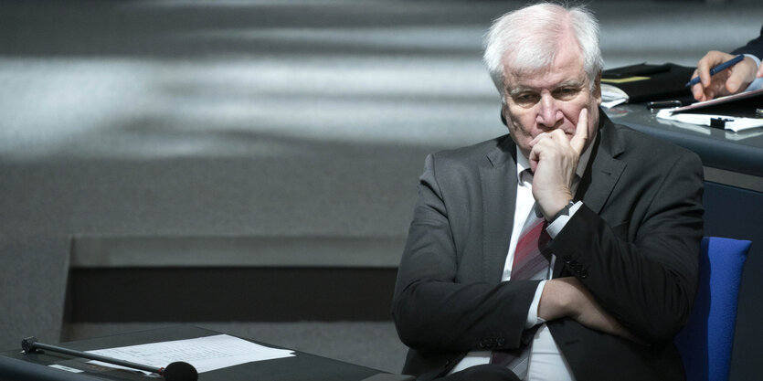 Horst Seehofer sitzt auf seinem Platz im Bundestag und hat den Kopf in die Hand gestützt