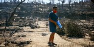 Ein Junge steht in den Brandruinen von Moria