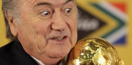 Fifa-Präsident Blatter mit aufgerissenen Augen vor dem WM-Pokal
