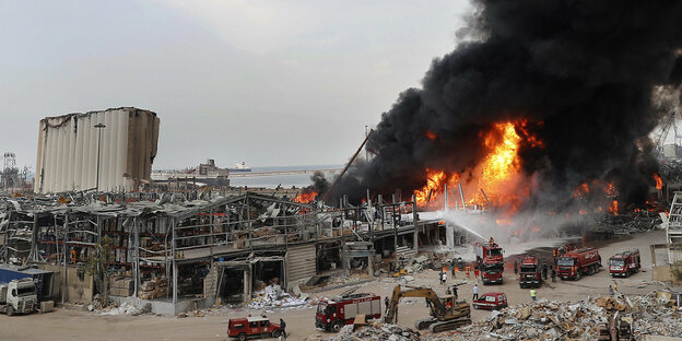 Ein Feuer im zerstörten Hafen von Beirut