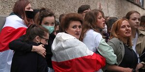 Frauen stehen beieinander, eine hat sich die Fahne der russischen Oppsition umgehängt