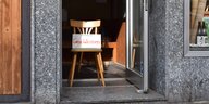 Ein Stuhl steht in einem Türrahmen, darauf ein SChild mit der Aufschrift "Geschlossen"