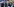 Mann mit Mundschutz inmitten von Protestlern mit Plakaten in EU-Blau.