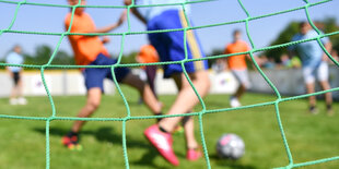 Kinder spielen Fußball auf einem Sportplatz