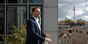 Jens Spahn lehnt am Terrassengeänder des Ministeriums, mit Blick auf Berlin