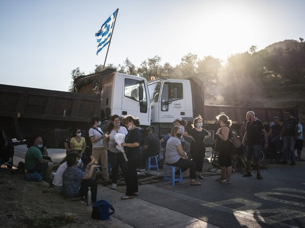 GriechInnen haben die Straße für Geflüchtete blockiert, mit LKWs und Stühlen