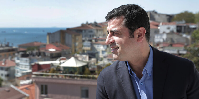 Selahattin Demirtas steht auf einem Balkon vor einer Stadt am Meer