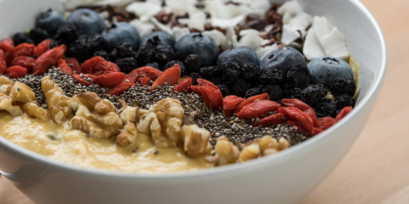 eine Schale mit Nüssen, Blaubeeren und anderen Zutaten für ein Frühstück