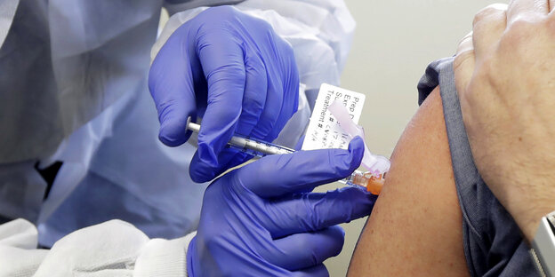 Eine Versuchsperson erhält eine Spritze mit einem potenziellen Impfstoff der US-Biotech-Firma Moderna gegen Covid-19.