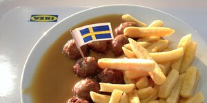 Fleischbällchen mit Pommes und einer schwedischen Fahne.
