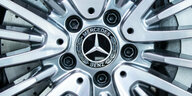 Das Logo des Autoherstellers Daimler. Im Vordergrund der Teil einer Autofront