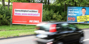 Wahlplakate der Linken und der SPD an einer Straße.