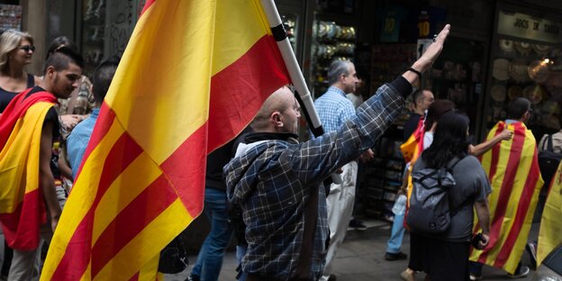 Mann mit spanischer Fahne macht einen Francogruß.
