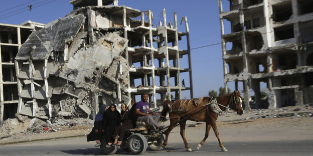 Eine palästinensische Familie passiert auf einem Pferdewagen Ruinen in Beit Lahiya.