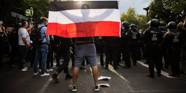 Ein Mann hält eine Reichsflagge bei einem Protest gegen die Corona-Maßnahmen vor der russischen Botschaft