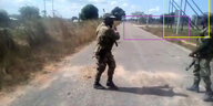 Zwei Soldaten stehen bewaffnet auf ener staubigen Straße