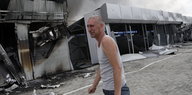 Ein Mann steht weinend vor seinem zerstörten Laden am Stadtrand von Donezk