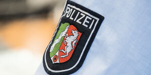 Ein Abzeichen der nordrhein-westfälischen Polizei, fotografiert auf einem Hemd in der Landesleitstelle der Polizei