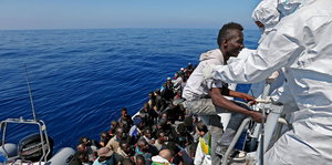 Flüchtlinge besteigen ein Boot, das sie nach Italien bringen soll