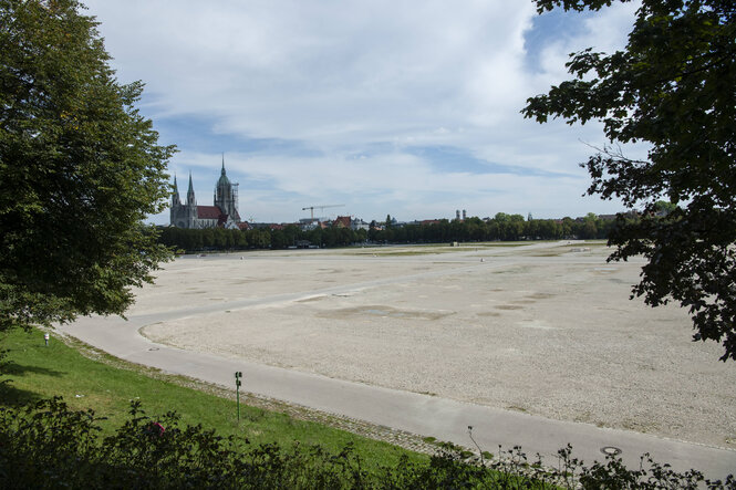 Blick auf die leere Theresienwiese, im Hintergrund eine Kirche