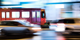 Eine Straßenbahn fährt neben einer Straße mit Autos